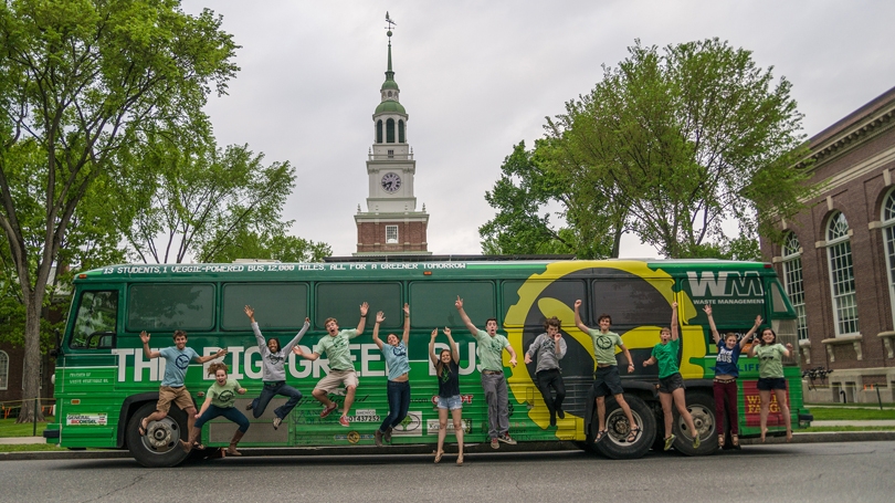 big green bus crew members jumping